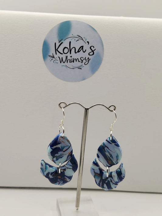 Blue marbled earrings by Koha's Whimsy, with silver hooks and decorative semi-circular elements.