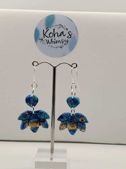 Dangle earrings with lotus blooms by Koha's Whimsy, featuring blue and teal swirl patterns and gold accents.
