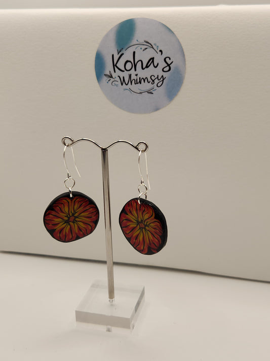 Flame blossom dangle earrings displayed showing bold red and yellow flower pattern with elegant contrast
