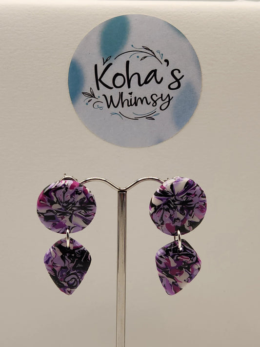 Stud earrings in violet chaos color by Koha's Whimsy, with round and diamond-shaped polymer clay drops.