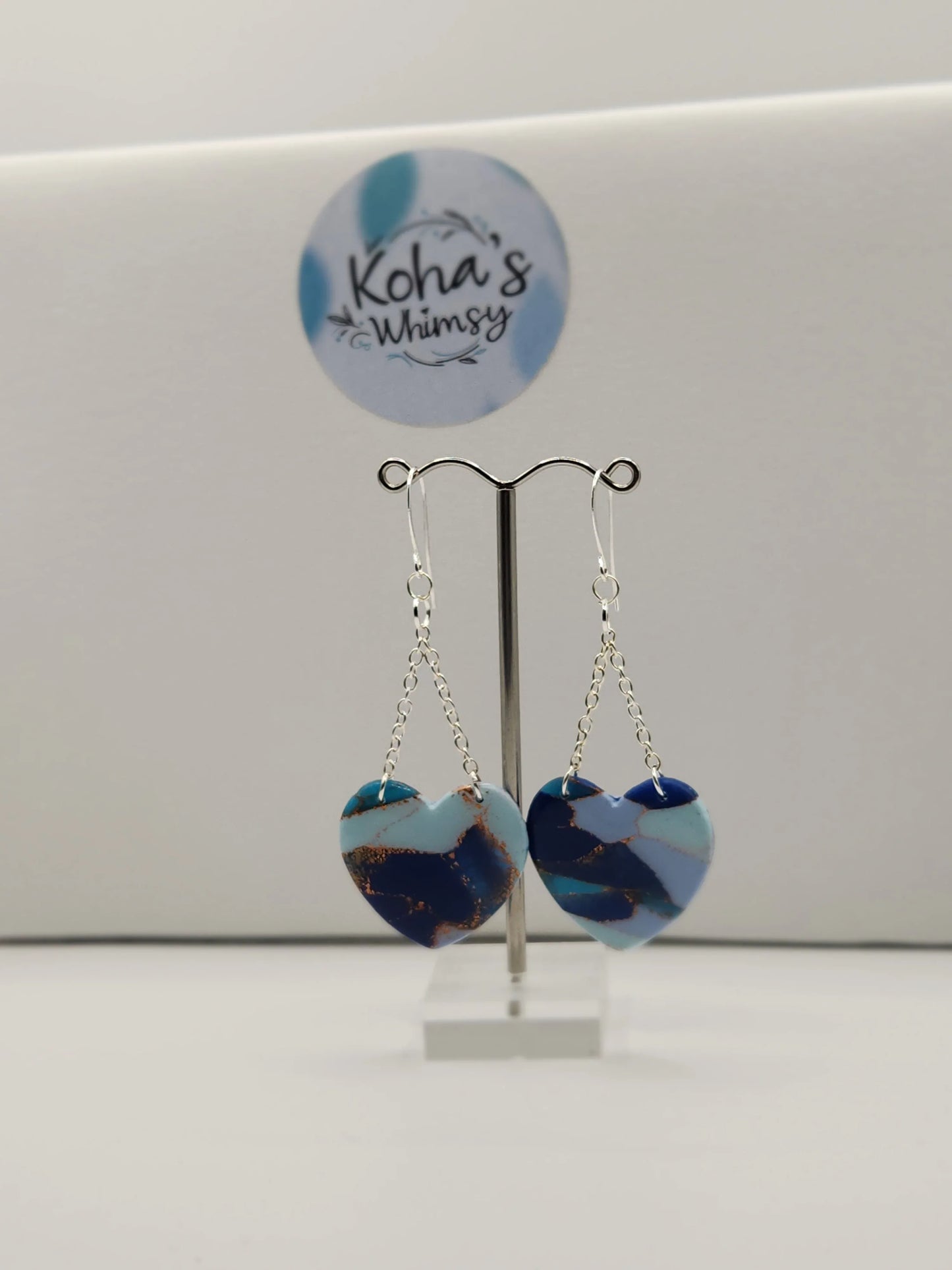 Blue heart dangle earrings by Koha's Whimsy, with silver chain and swirls of copper color.