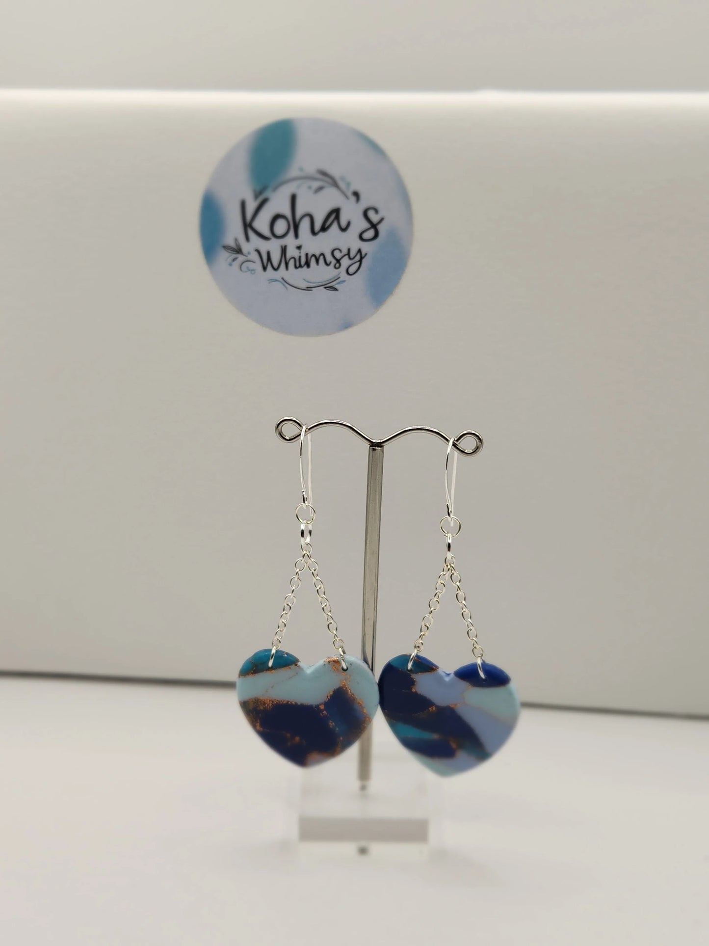 Heart dangle earrings by Koha's Whimsy, featuring an ocean-inspired color palette with a marbling effect and silver-tone chains.