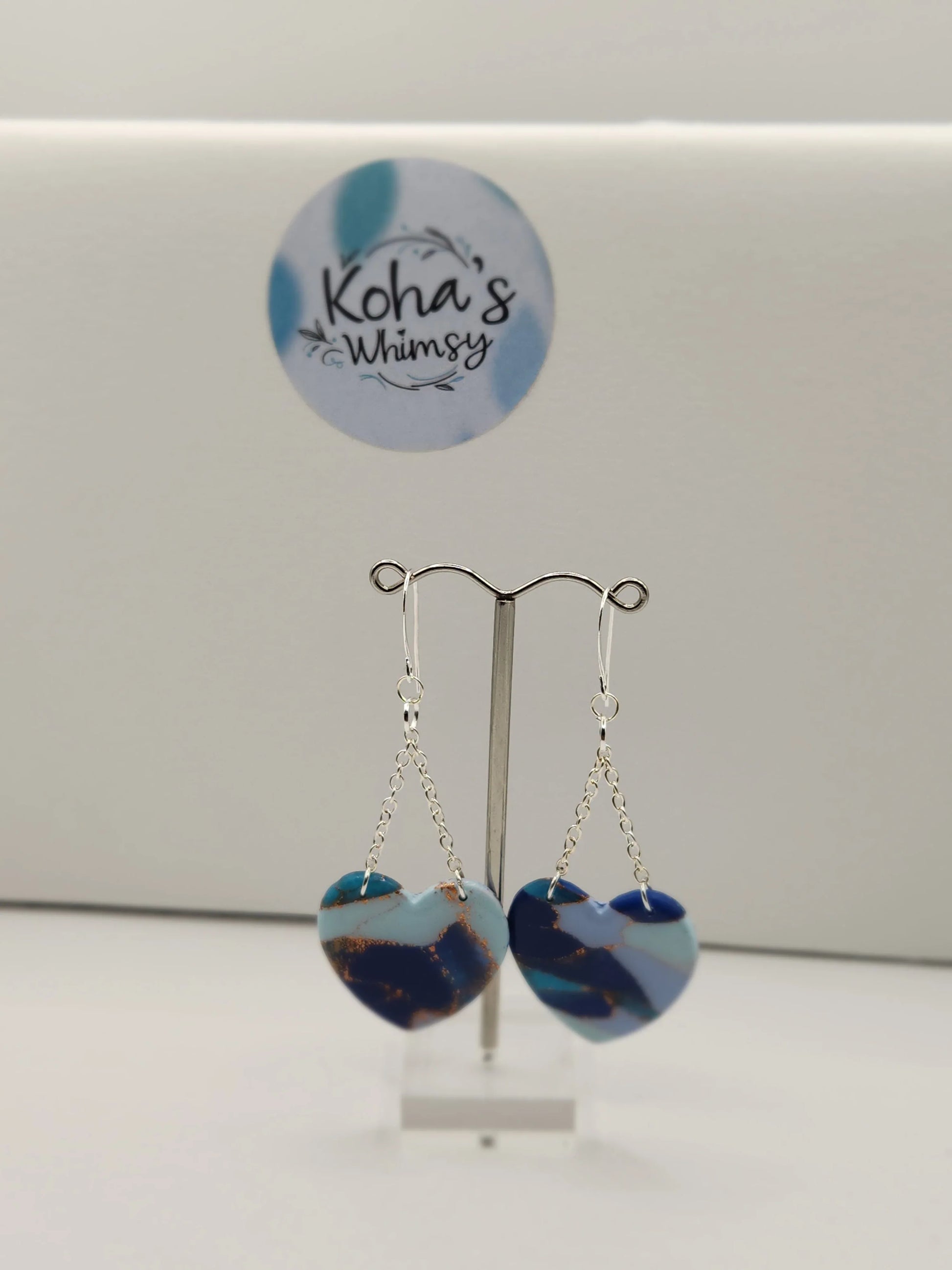 Heart dangle earrings by Koha's Whimsy, featuring an ocean-inspired color palette with a marbling effect and silver-tone chains.