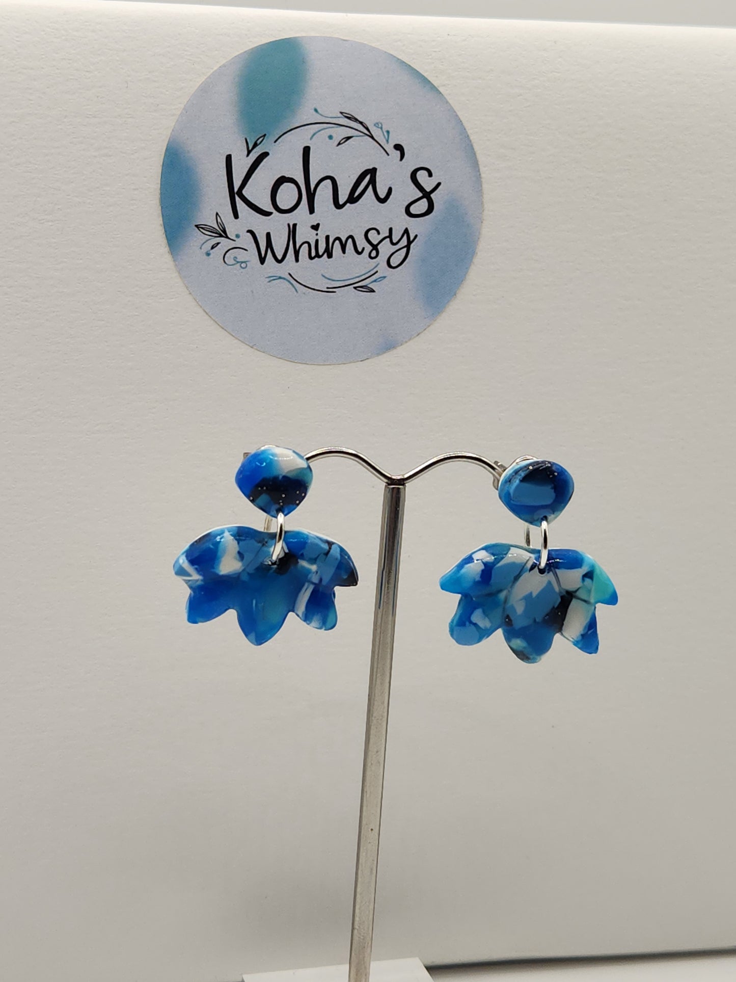 Handmade polymer clay lotus bloom stud earrings with navy burst design in blue and white
