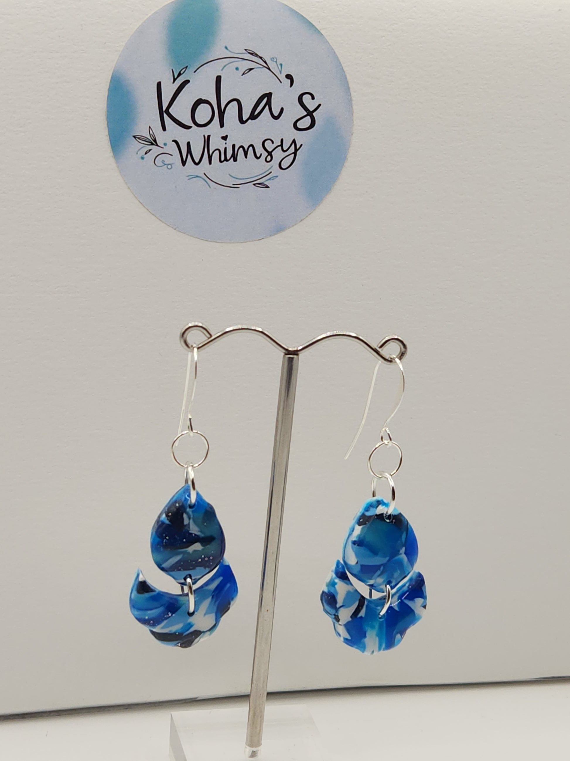 Handmade polymer clay cascading petal dangle earrings with navy burst design in blue and white
