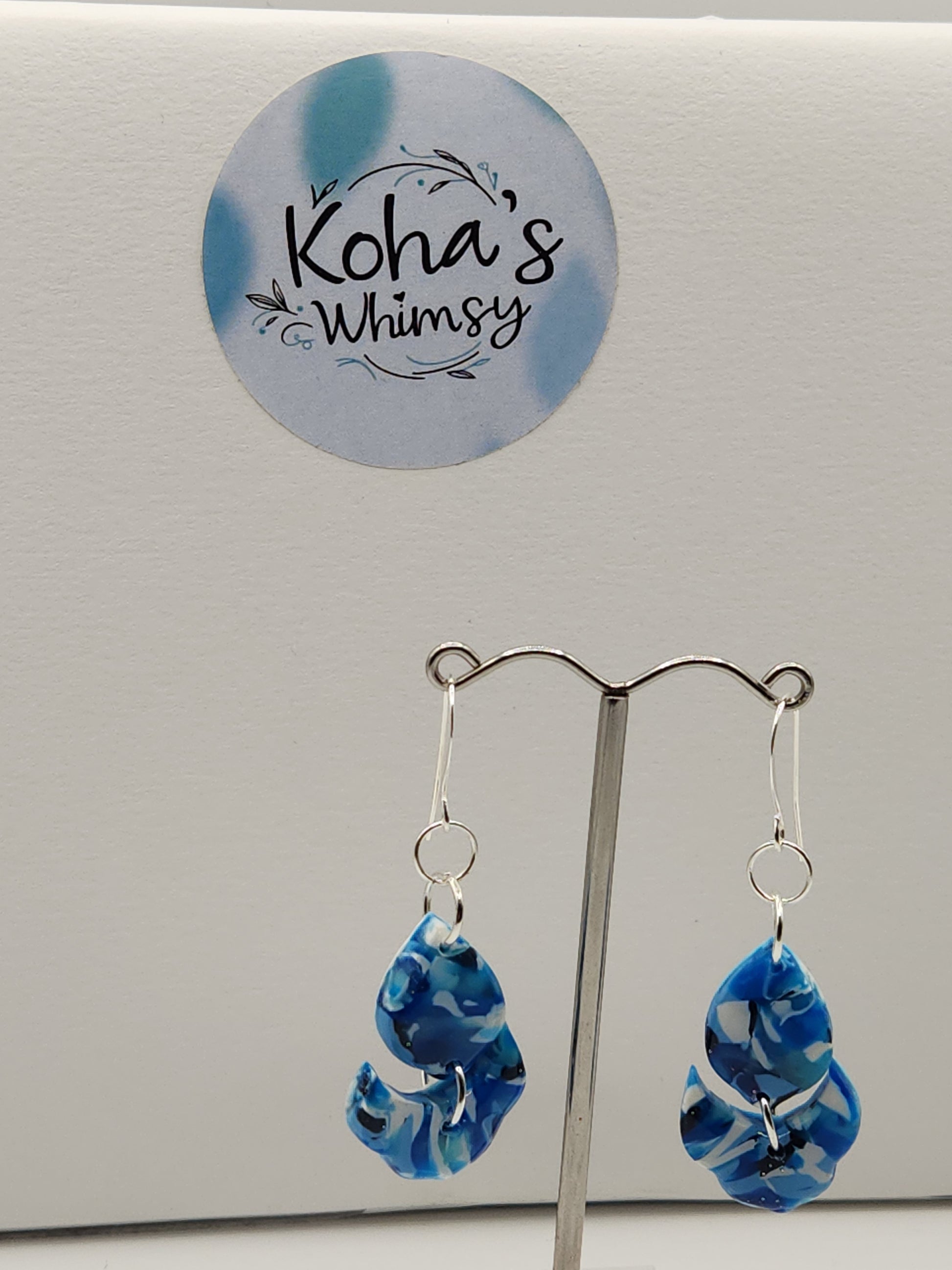 Close-up of navy burst earrings showing artful blend of blue and white with floral petal design
