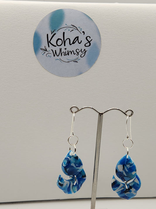 Close-up of navy burst earrings showing artful blend of blue and white with floral petal design
