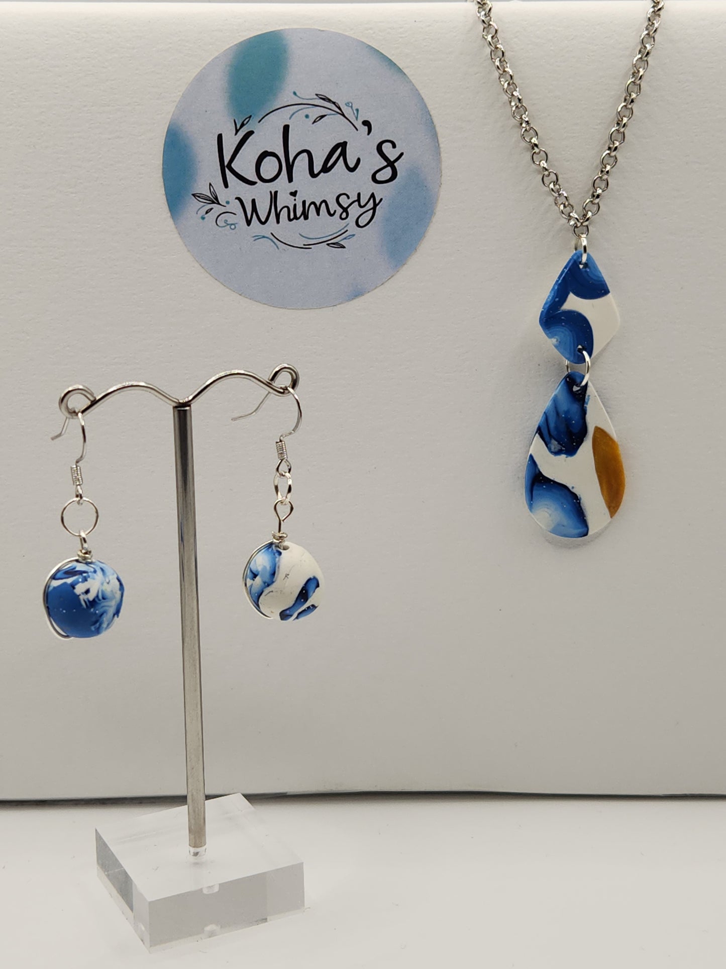 Handmade polymer clay jewellery set with galactic blue shimmer including wire-wrapped bead dangle earrings and elongated teardrop pendant
