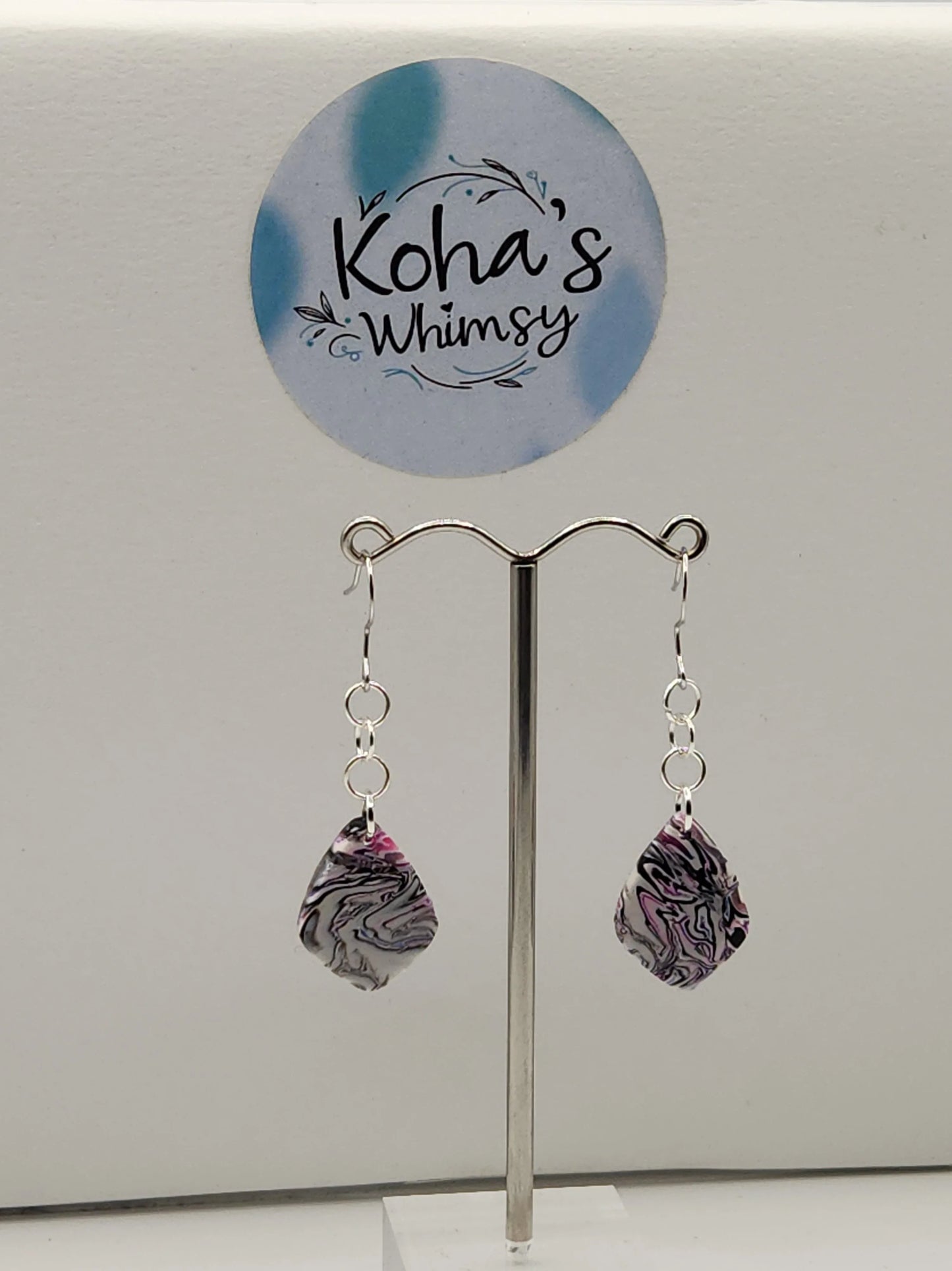 Dangle earrings with small teardrop gems by Koha's Whimsy, displaying a marbled white, black and magenta pattern.