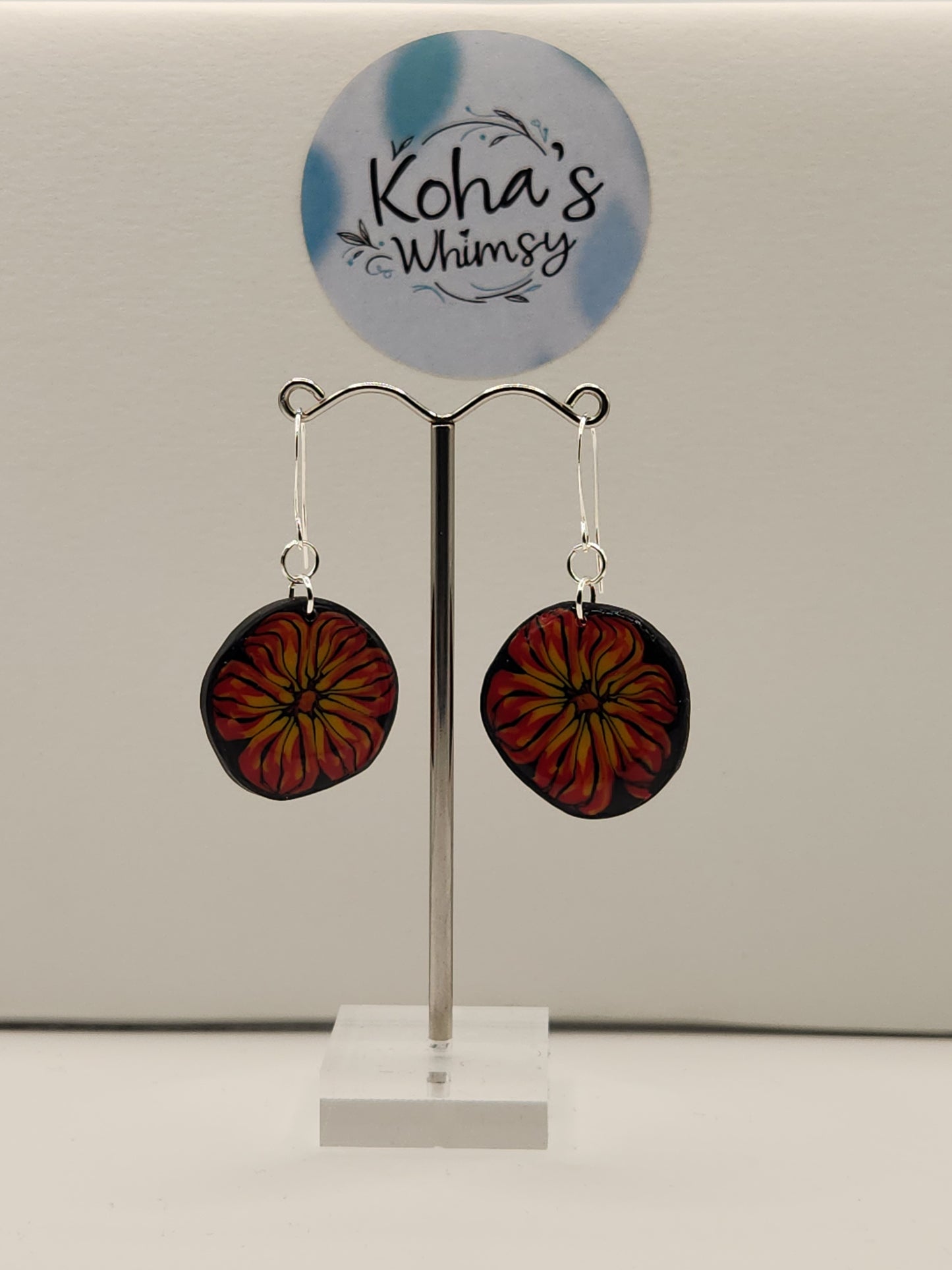 Close-up of flame blossom earrings showing detailed handcrafted red and yellow floral design
