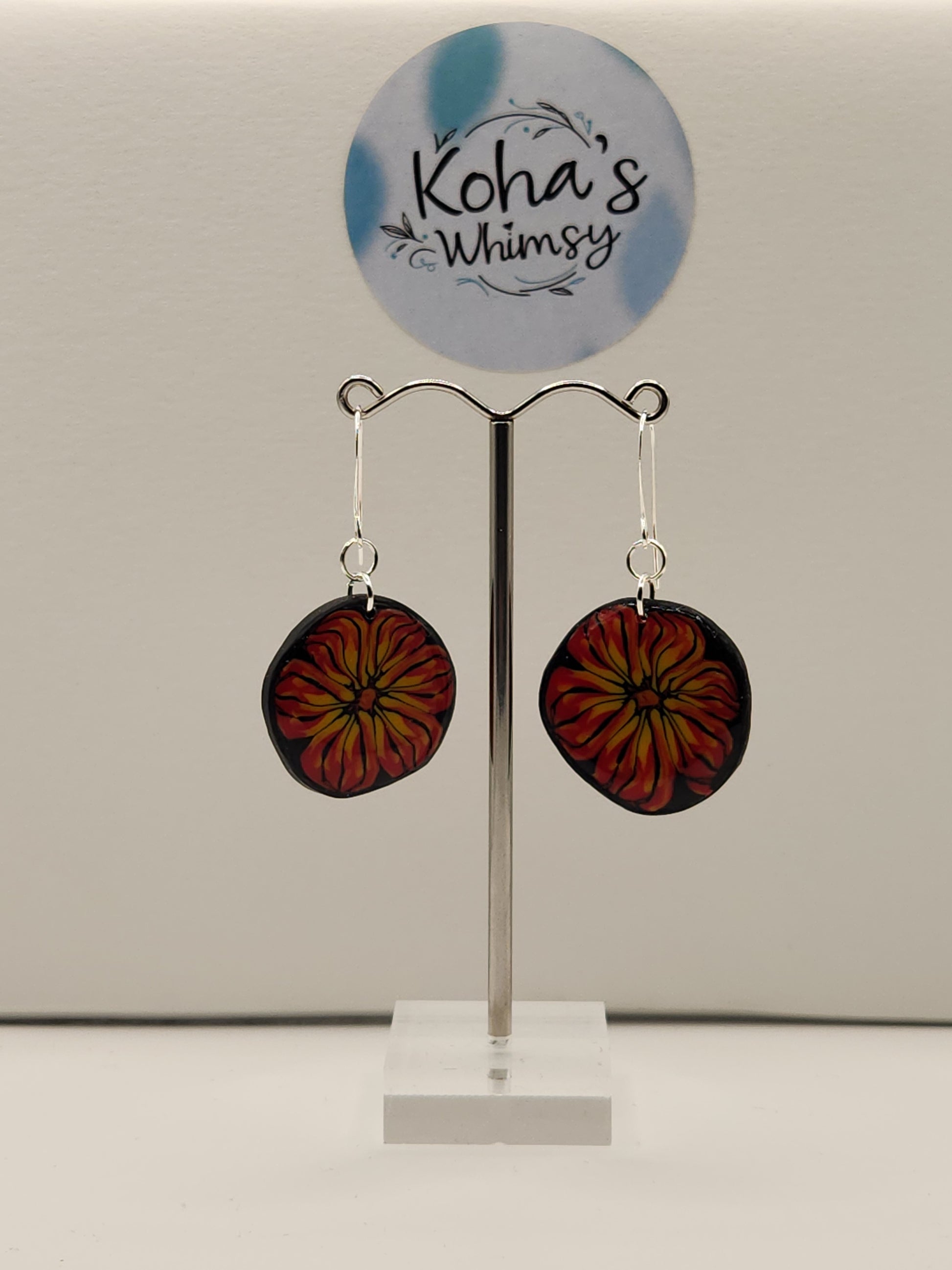 Handmade polymer clay flame blossom dangle earrings with vibrant red and yellow flowers on black background"

