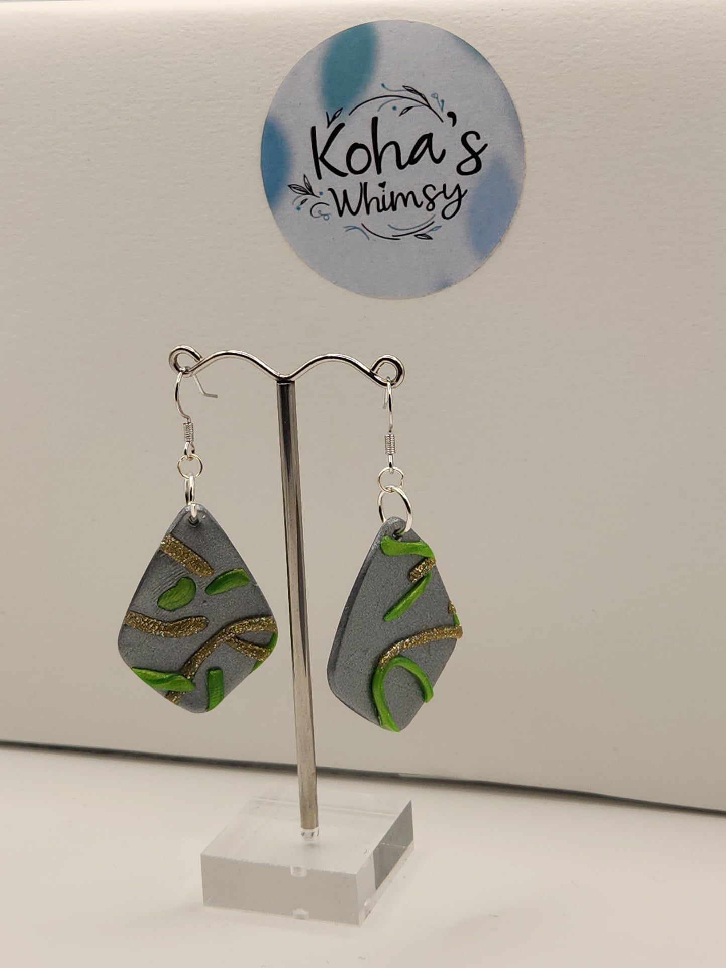 Side view of abstract swirls earrings displaying elegant drop diamond shape and artisan detail 