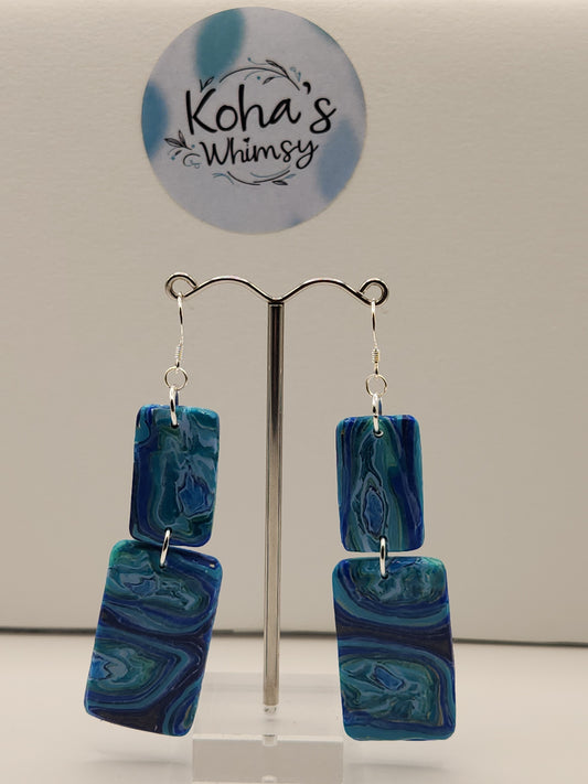 Close-up of blue agate rectangle earrings showing natural stone veining and sterling silver detail
