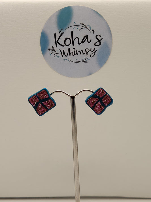 Close-up of fuchsia diamond studs showing vibrant colour blend with teal outline and sophisticated design