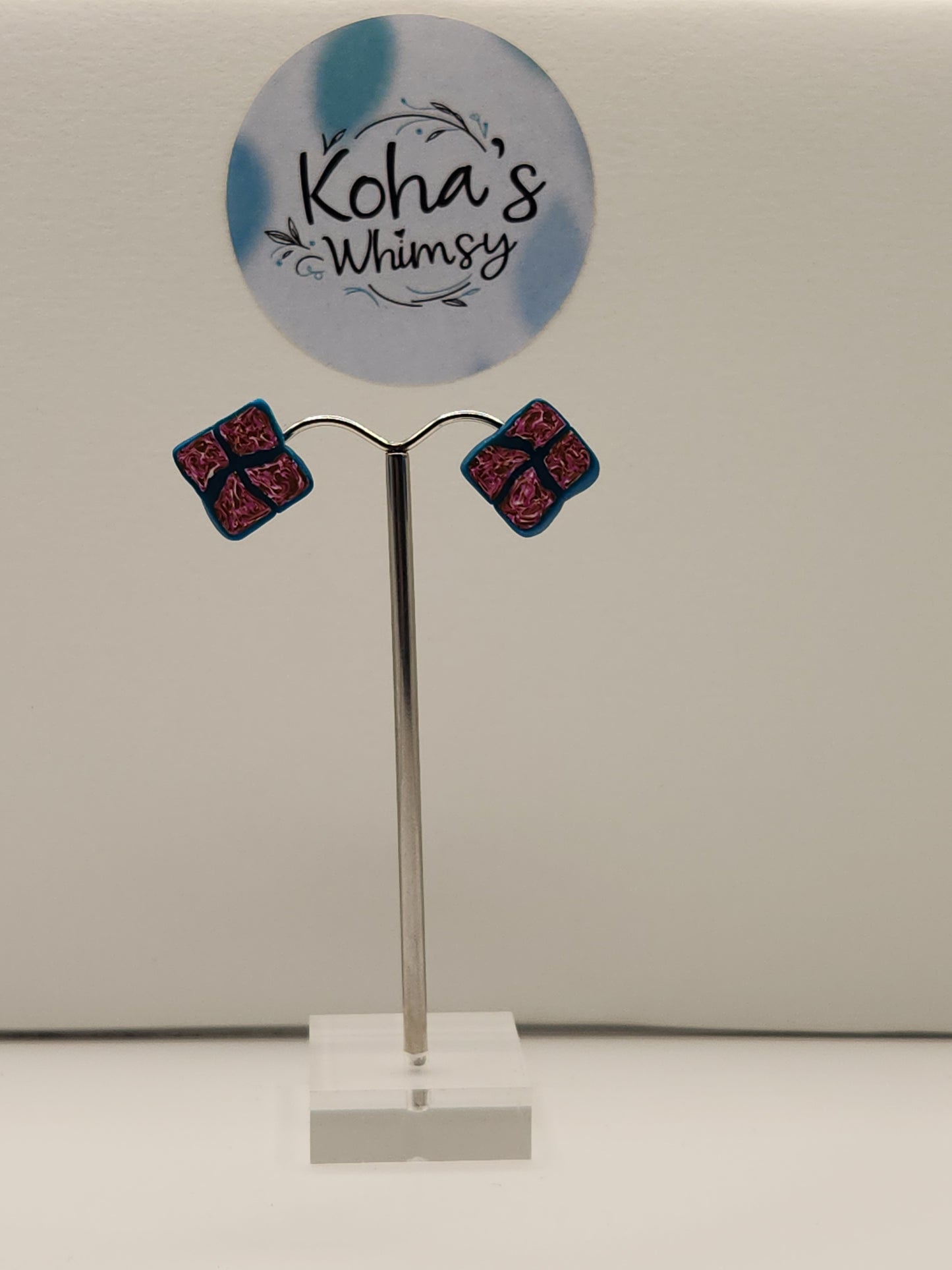 Fuchsia diamond stud earrings displayed showing small diamond shape with fuchsia, gold and white colour sections