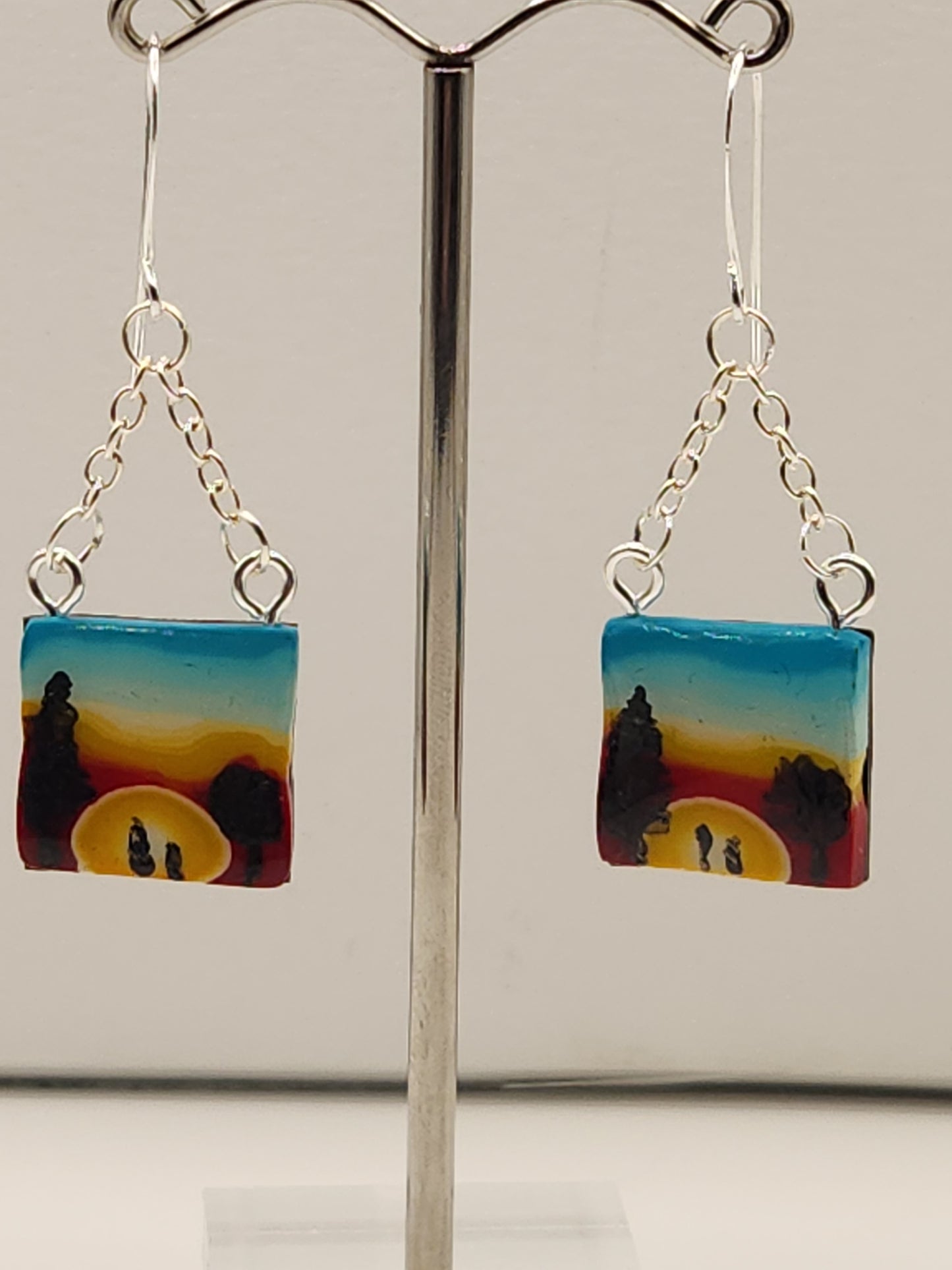Handmade polymer clay dangle earrings with sunrise gradient and silhouette of couple and trees