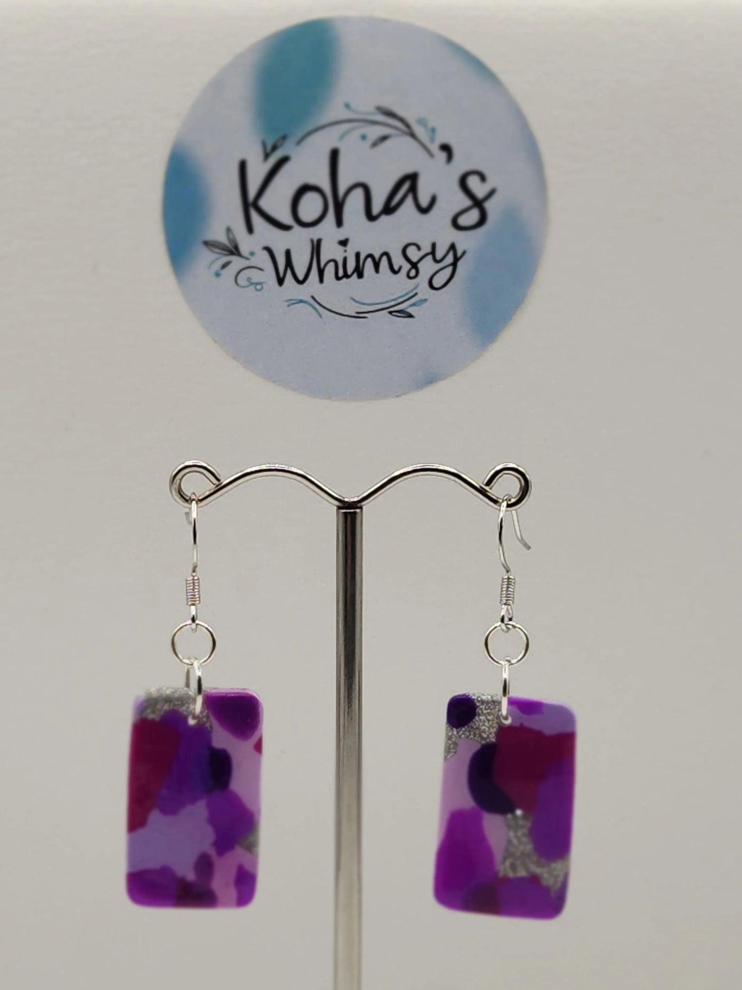 Purple rectangle dangle earrings by Koha's Whimsy, with abstract shapes and silver glitter accents.