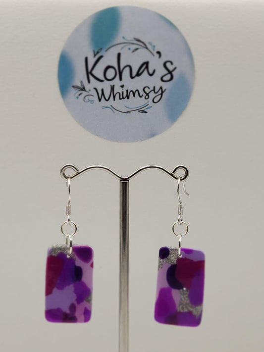 Close-up of purple droplets earrings showing rich purple fluid patterns and artistic visual effect
