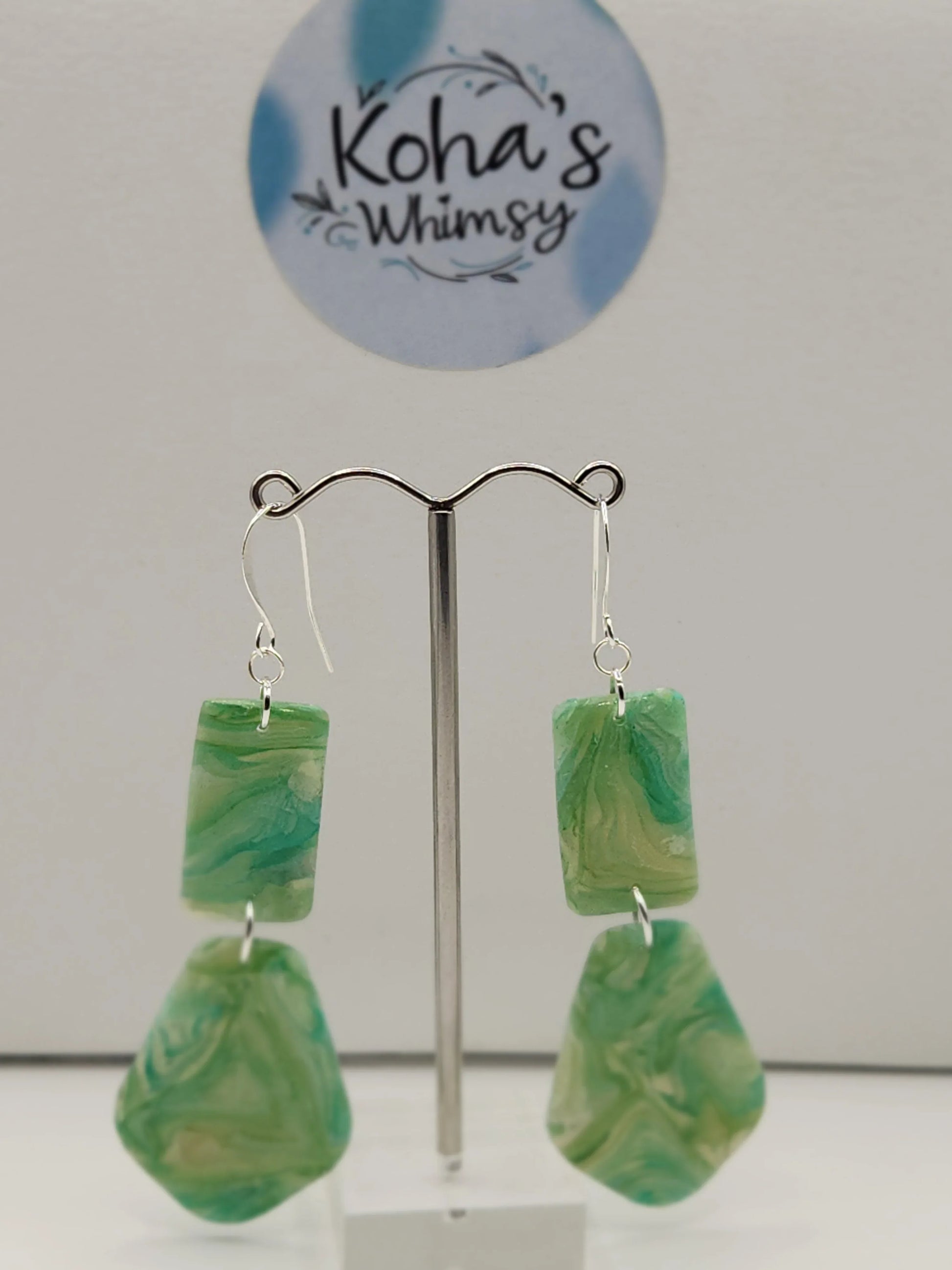 Green and beige moss agate earrings from Koha's Whimsy, featuring a rectangular piece above a teardrop shape.